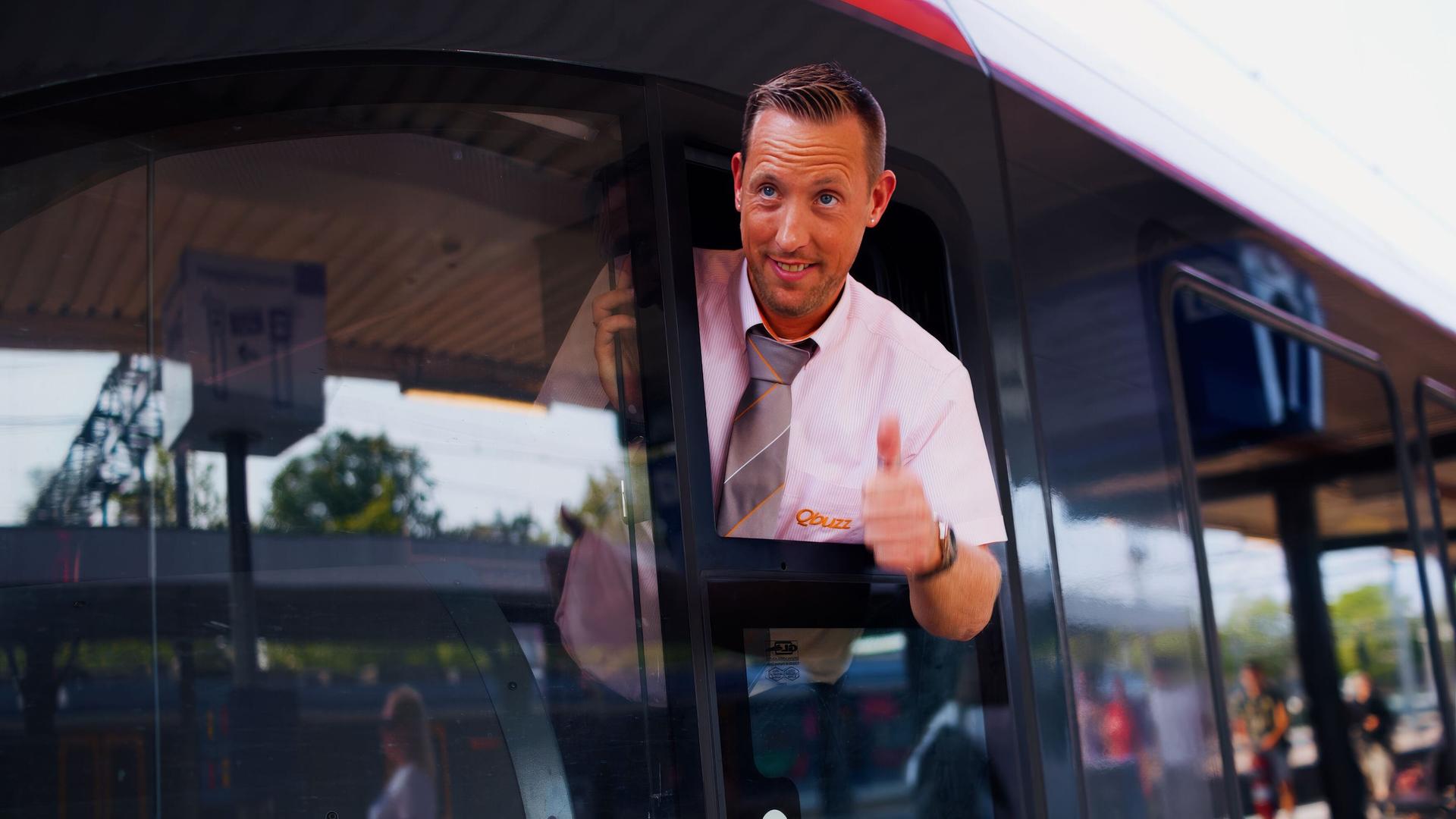 Trein machinist kijkt steekt zijn hoofd uit het raam en steekt zijn duim omhoog