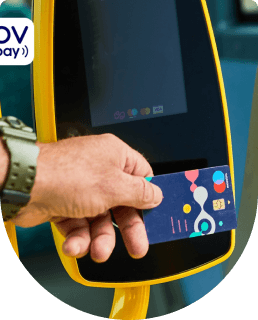 Een hand heeft een bankpas vast en checkt in bij een incheckautomaat in de bus