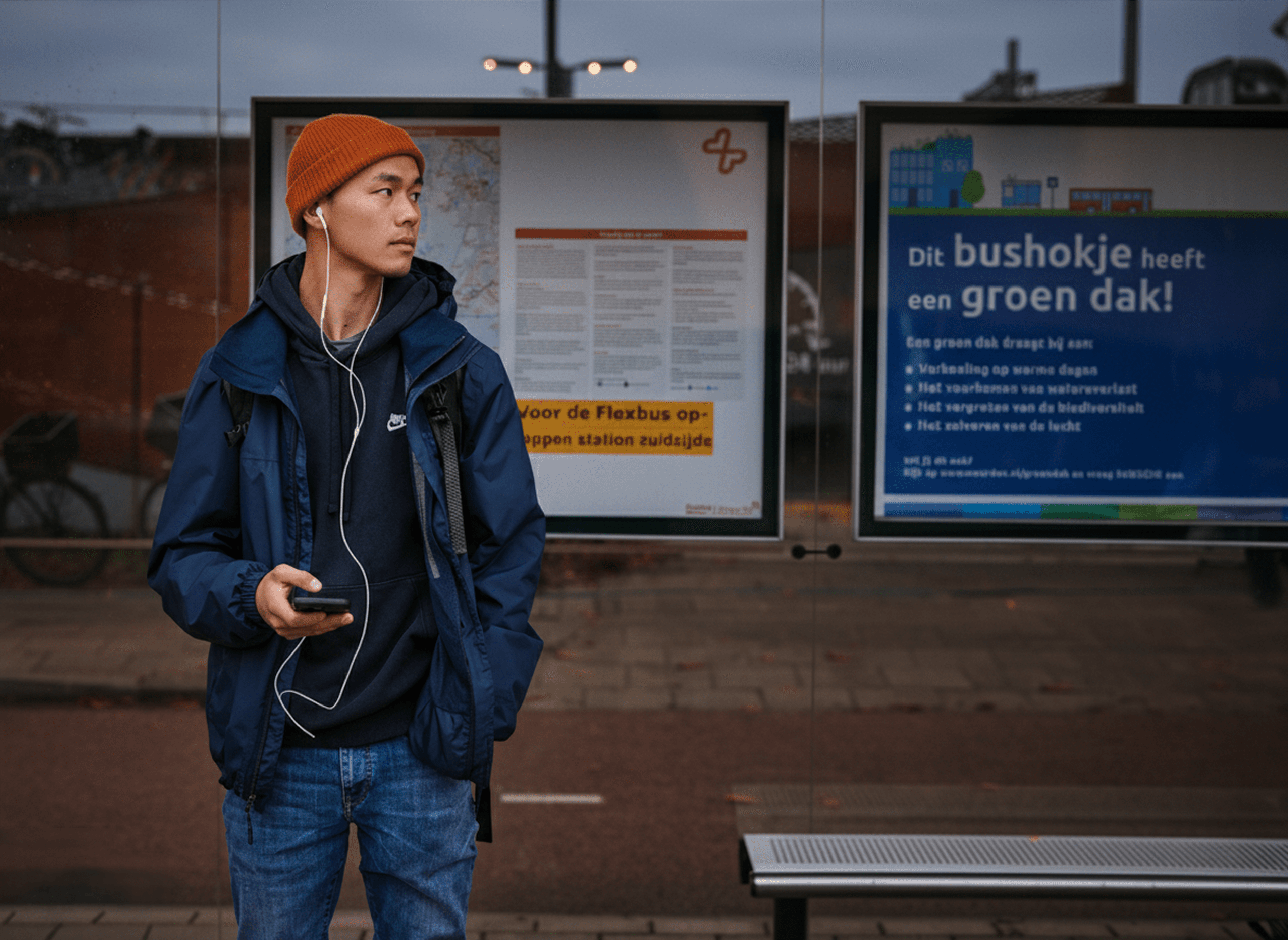 Reiziger staat bij de bushalte op de bus te wachten.