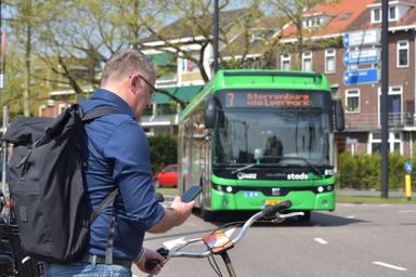 Drie reizigers staan in de rij voor de bus